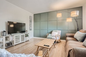 The cozy living room greets you upon entering designed with a beautiful accent wall.