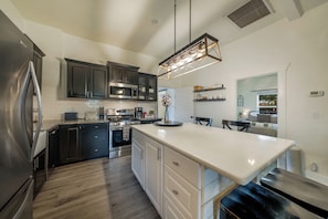 Spacious kitchen, open to living room, with large island for gathering around