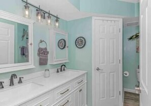 Newly updated master bathroom featuring double vanity sinks and shower with glass door!