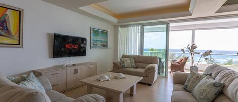 Spacious living room with smart tv, access to balcony and kitchen, A/C.