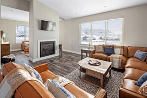 Main level living area with a cozy double-sided see-through fireplace adjacent to the sitting area. 