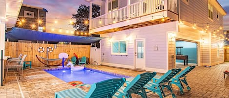 [Backyard] Outdoor courtyard between main hours and carriage house complete with seating for 16, out door games with corn hole area. Overlooking the pool and outdoor TV