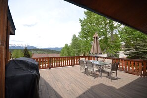 Exterior view of the deck with beautiful mountain views, outdoor dining area and gas BBQ grill.