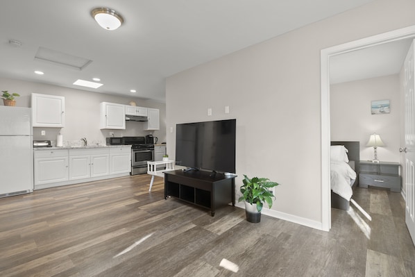 Spacious Living room with natural light, 65” TV for Netflix shows.