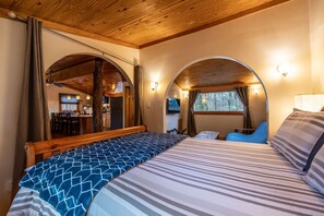 The bedroom has a view of the living room and the sitting area