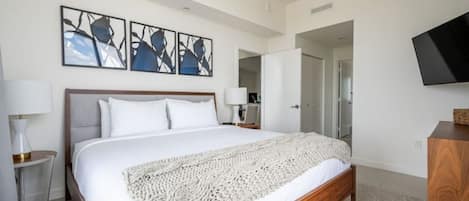 Master bedroom has a luxury king bed with corner views of the city.