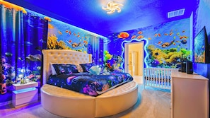 The master bedroom features a luxuriously large king bed with a crib