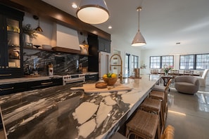 A well-appointed, fully stocked chef's kitchen, complete with statement-stone countertops