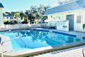 Beautiful, heated pool with lounge chairs, tables with umbrellas and poolside restrooms.