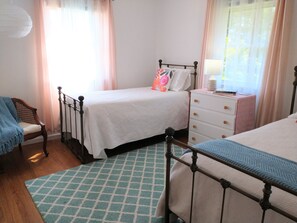 Twin beds with room-darkening cellular shade option, dresser, and closet space.