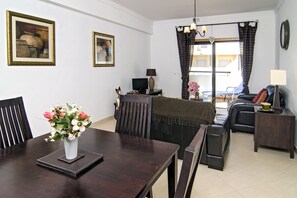 Living room with dining table and two black leather sofas