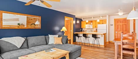 Living & kitchen area w/ an oversized couch to keep large groups comfortable.