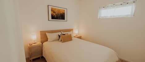 Unwind in this cozy bed, featuring a comfortable bed, soft linens, and a touch of natural light.