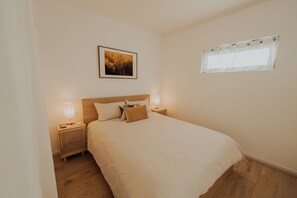 Unwind in this cozy bed, featuring a comfortable bed, soft linens, and a touch of natural light.