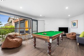 The ground floor living room is a dedicated recreation room, with a pool table