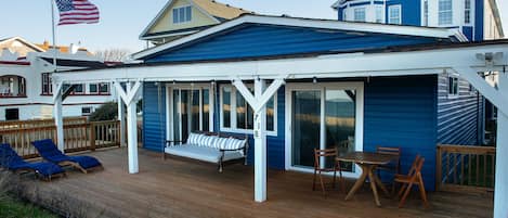 Beach deck with bed swing, sun loungers and eating area.