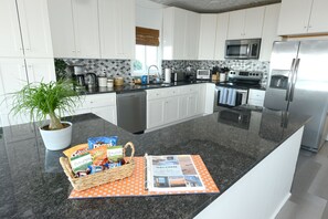 Large fully stocked chef's kitchen with complimentary snacks, coffee and tea.