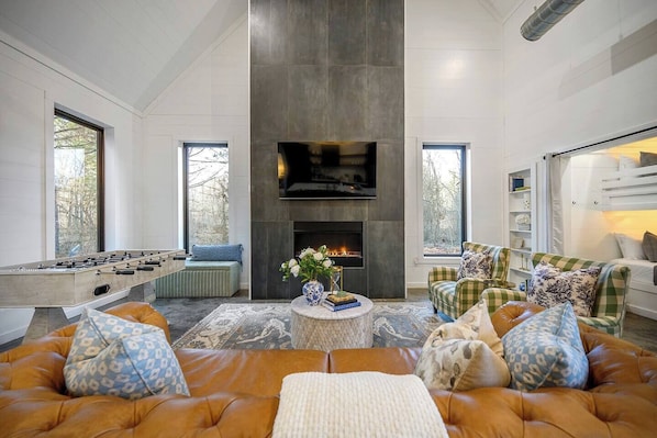 Living room w/ smart TV, gas fireplace, foosball table, and bunk nook