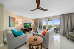 Living room with Flat TV, ceiling fan and balcony on the outside