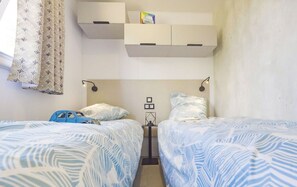 Cozy twin beds in a bright room, offering a comfortable space to recharge after a day of adventure.