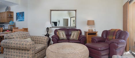 The living room with leather sofa and recliner. chair and large ottoman.