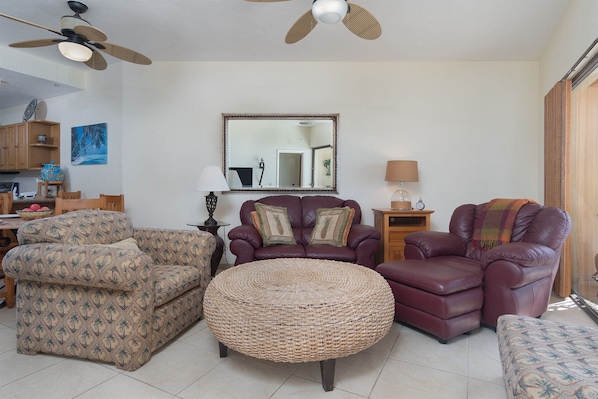 The living room with leather sofa and recliner. chair and large ottoman.