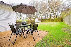 Covered seating overlooking the large fenced yard.