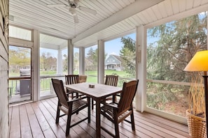 Relax and enjoy some fresh air and conversation on this cozy screened-in porch.