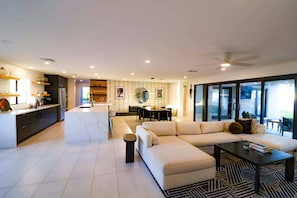 Spacious great room featuring a large sectional sofa, abundant natural light, a large HDTV with cable, and board games for added fun!