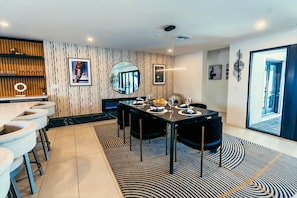 Sleek, modern dining area with designer accents — perfect for elegant dinners or casual gatherings, all just steps from the kitchen bar."