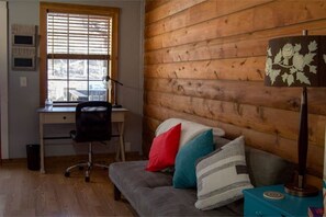 Bonus room has a office desk with chair and light, yoga mat, TV is to the left.