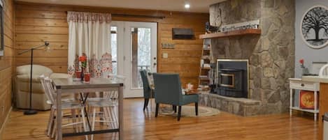 Multi-purpose room - one side of it with wood burning fireplace and dining table