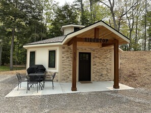 Up close view of the front patio with table and chairs, and outdoor grill.