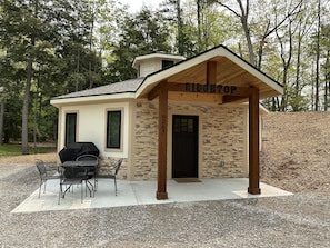Up close view of the front patio with table and chairs, and outdoor grill.