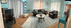 Lovely living room featuring echoes of the ocean. Bay window, leather furniture
