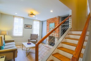 The living room features a sofa, arm chair and built-in bookcase with a smart TV.