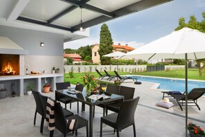 Überdachte Terrasse der Kroatien Luxusvilla Medulin mit privatem Pool und Esstisch mit Außengrill zum Genießen mit Freunden