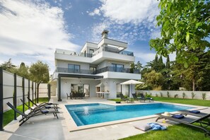 Blick auf die private Kroatien Luxusvilla Medulin mit Pool und Liegestühlen mit Sonnenschirm zum Mieten