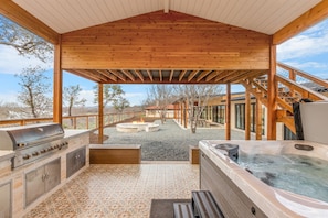 Covered area with outdoor kitchen and hot tub.