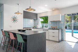 Peninsula seating in main kitchen with window pass through to pool.