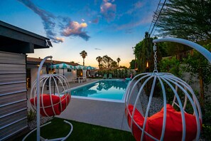 Swinging basket chairs with outdoor ping pong table.