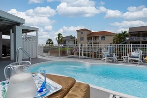 Relax poolside with a cold beverage and enjoy a sunset over the channel of this waterfront home.