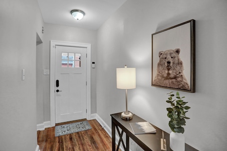 Welcoming entry with rustic decor, cozy rug, and modern lighting.