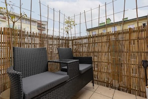Spacious balcony with outdoor furniture. 