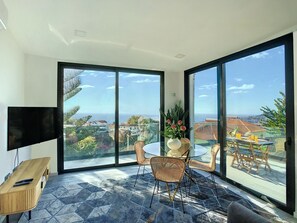 Bask in natural radiance and endless ocean views from the sun-soaked living room with expansive windows #oceanview #funchal #modernlivingroom