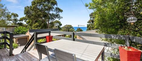 Elevated deck area with outdoor dining furniture and ocean views