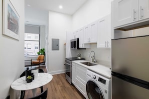 Enjoy home-cooked or the neighborhood's best takeout in this lovely kitchen with stainless steel appliances, a microwave, and a full-sized refrigerator.