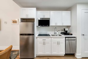 Enjoy making home-cooked meals or getting takeout in this lovely kitchen with stainless steel appliances and a full-size refrigerator