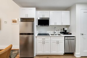 Enjoy making home-cooked meals or getting takeout in this lovely kitchen with stainless steel appliances and a full-size refrigerator