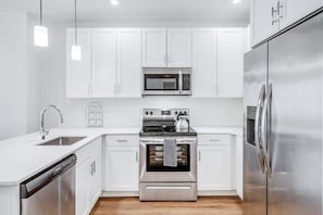 Enjoy making home-cooked meals or getting takeout in this lovely kitchen with stainless steel appliances and a full-size refrigerator